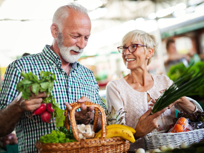 senior couple shopping for produce