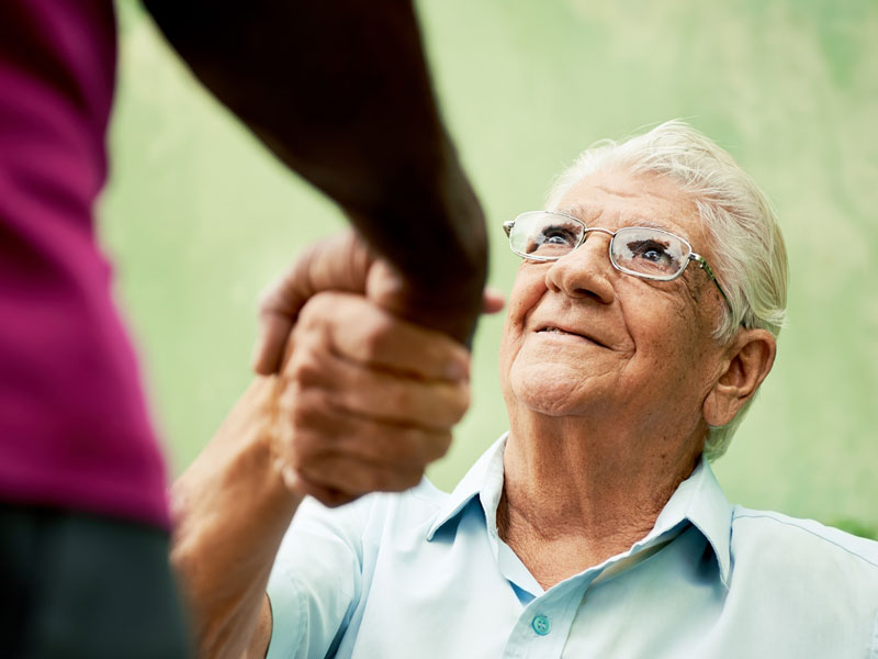 man helping a senior man up